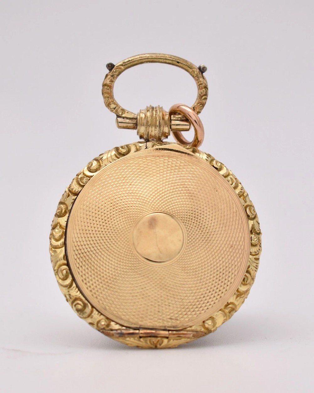 A circular gold locket pendant featuring a hand-painted portrait of a woman with dark hair against a light blue background. View IV