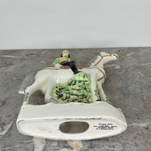 fig 7. A pair of hand-painted earthenware Staffordshire flatback figures depicting jockeys wearing yellow and green silks mounted on white horses.