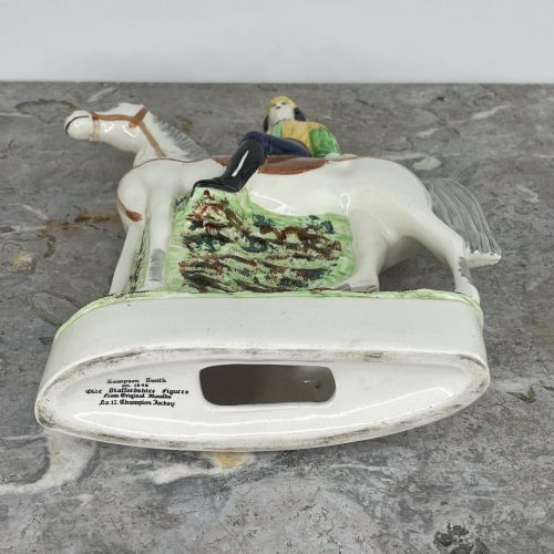 fig 8. A pair of hand-painted earthenware Staffordshire flatback figures depicting jockeys wearing yellow and green silks mounted on white horses.