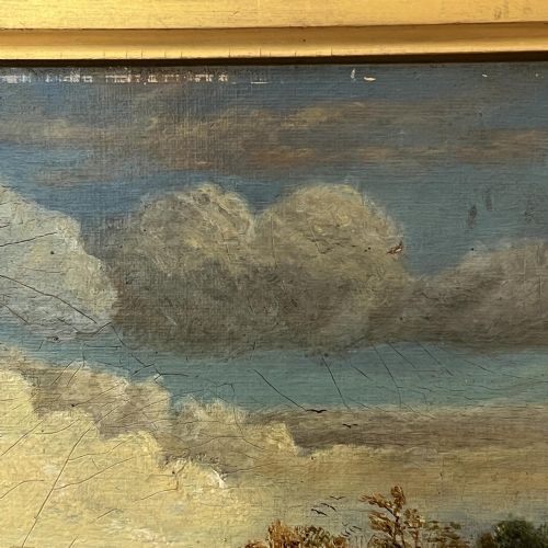 fig 5. A 19th-century oil painting featuring a figure walking along a dirt pathway towards a distant church spire under a sky filled with clouds, set within a wide gold frame.