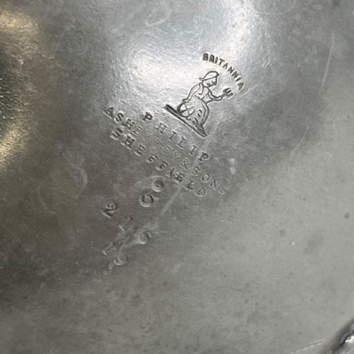 fig 3. A dark grey Victorian Britannia metal hot water pot featuring a high gooseneck spout, leaf-lobed body, scroll handle, and floral bud finial.
