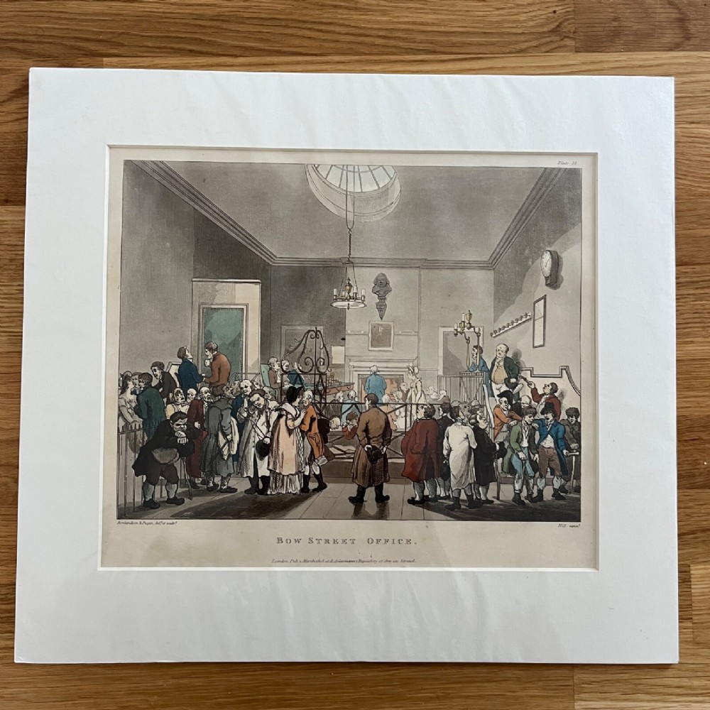 An 1808 hand-coloured aquatint depicting the interior of Bow Street Office filled with Georgian figures, mounted in a cream card mat.