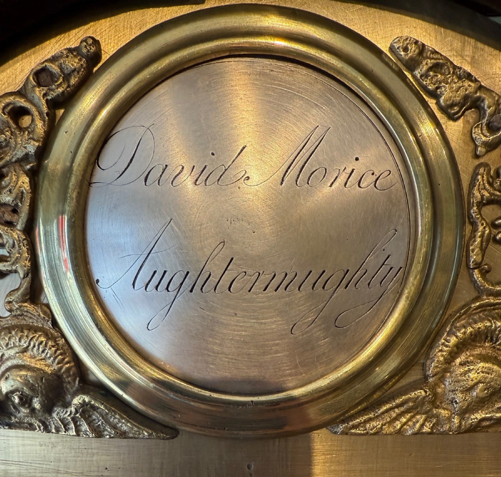 An early nineteenth-century Scottish mahogany longcase clock featuring an arched brass dial, urn inlay on the trunk door, and a molded pedestal base. View III