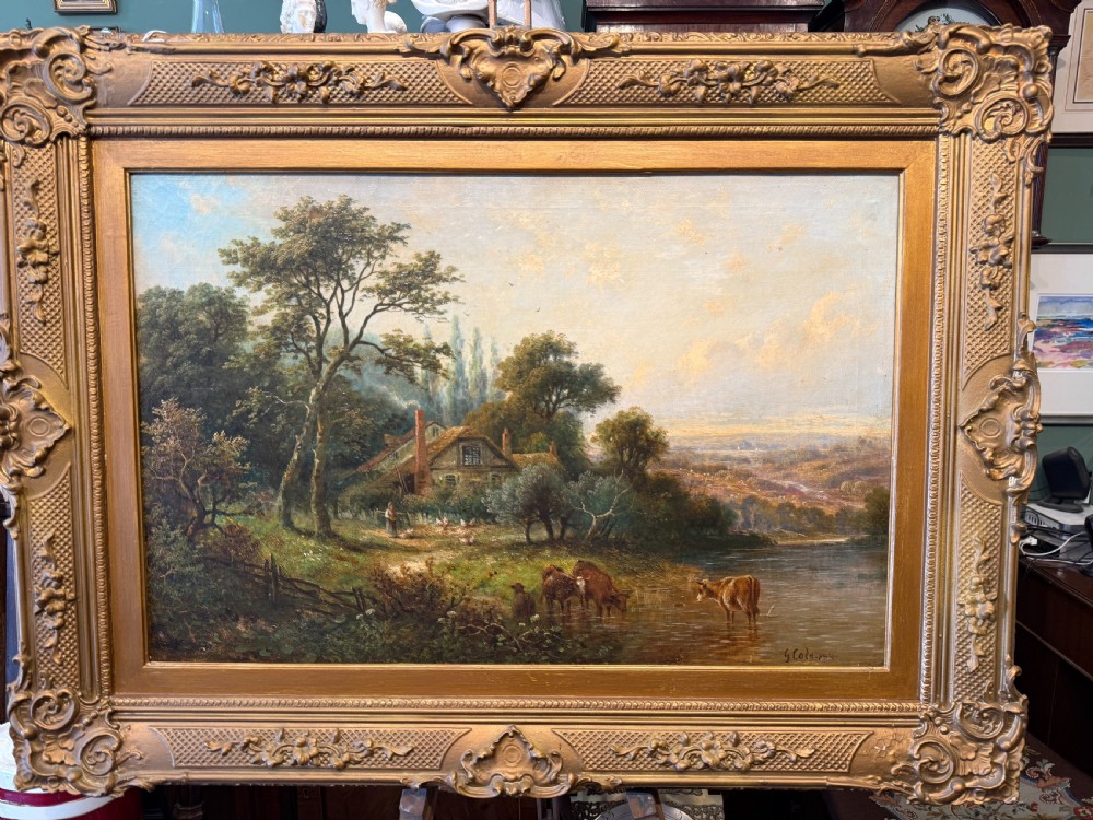 A nineteenth-century Victorian oil painting depicting cattle drinking from a river near a rural cottage, framed in an ornate gilded frame.