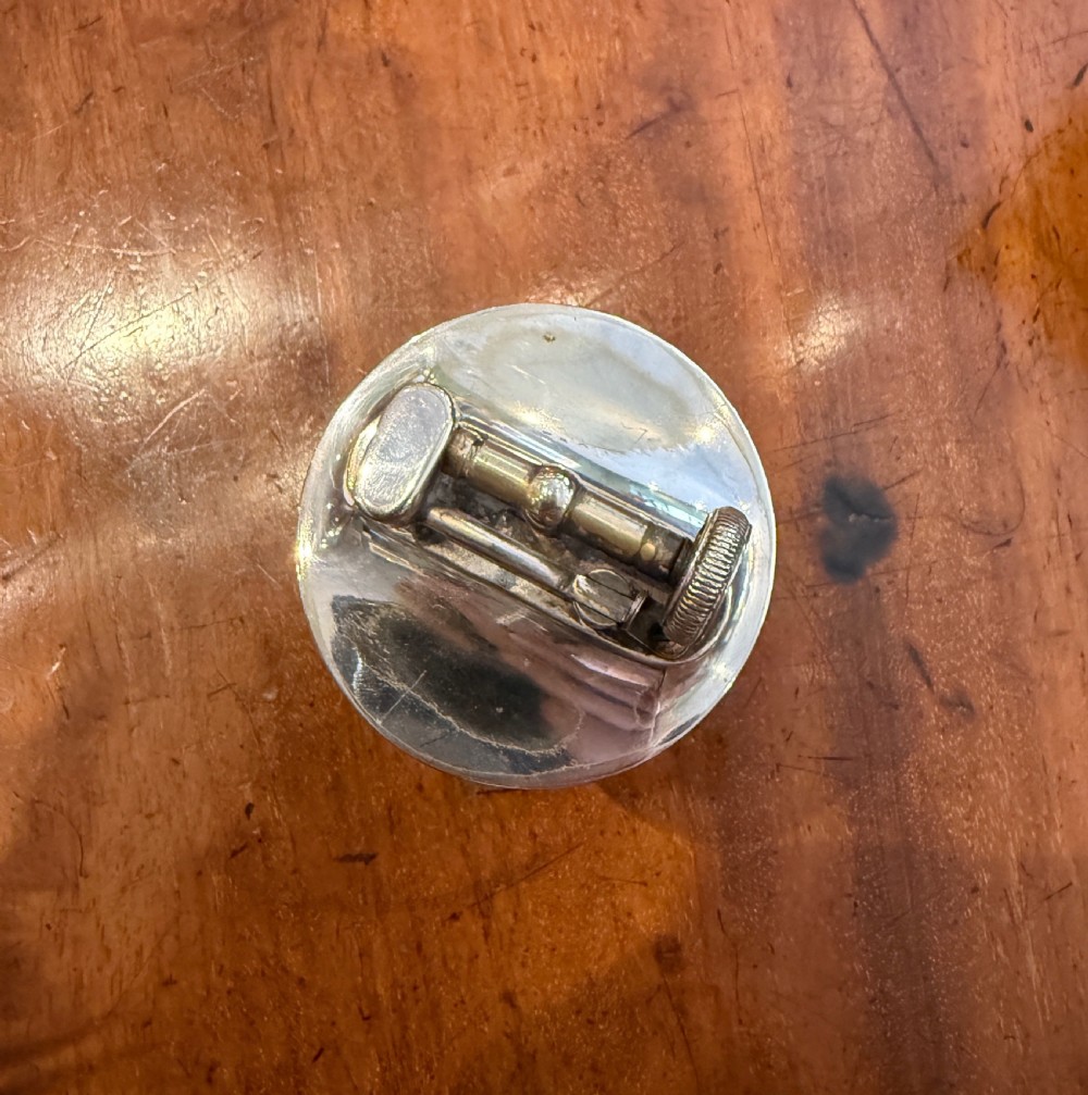 An Art Deco smoking set comprising a sage green shagreen cylindrical table lighter with silver metal fittings alongside a cream shagreen domed cigarette box resting on four small silver feet. View V