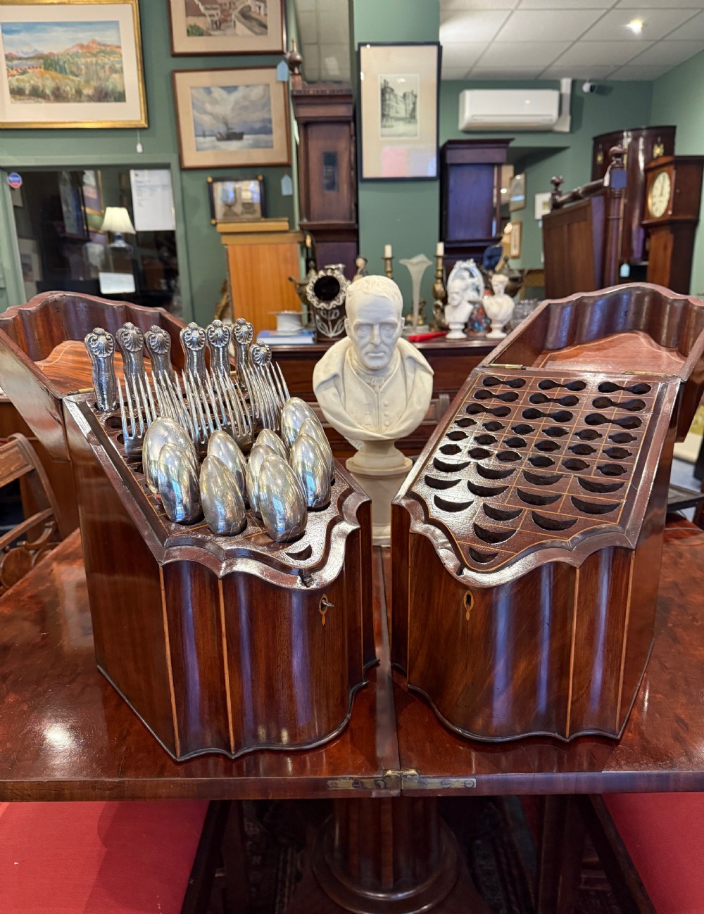 A pair of Georgian flame mahogany knife boxes featuring sloped lids, serpentine fronts, and oval patera marquetry inlays. View III