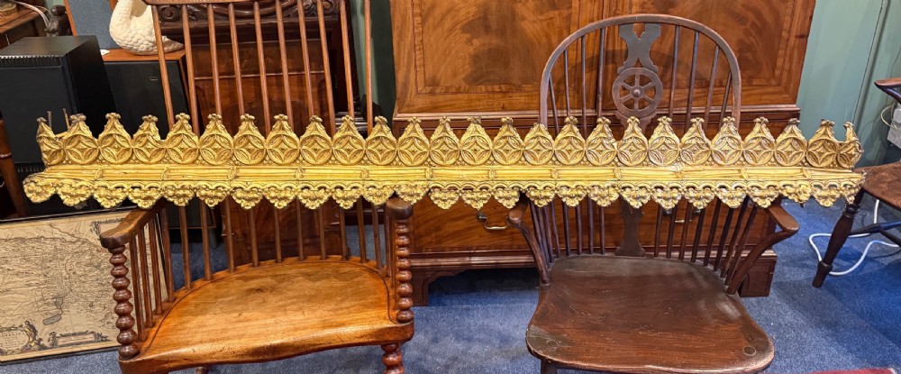 A pair of long Victorian gilt brass curtain pelmets featuring ornate Gothic cresting and pierced geometric star tracery. View II