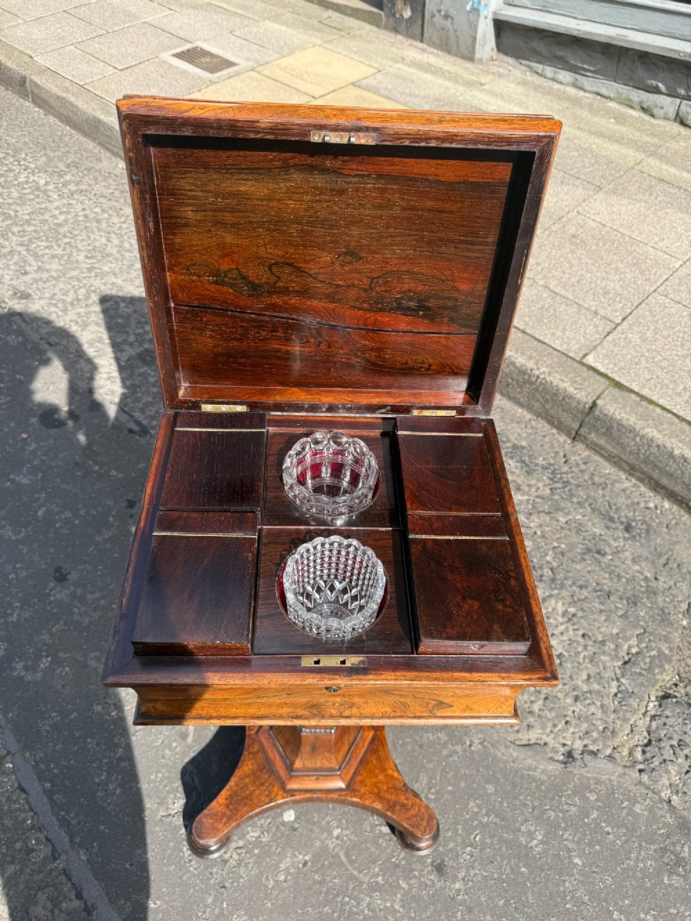 A Regency rosewood teapoy featuring a sarcophagus-shaped hinged lid, faceted pedestal column, and quadripartite plinth base on bun feet. View III