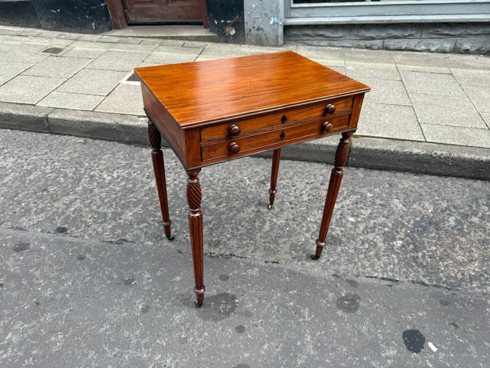 A Scottish Regency satinwood ladies work table featuring a rectangular top, two drawers with round knobs, spiral turned legs, and brass castors.