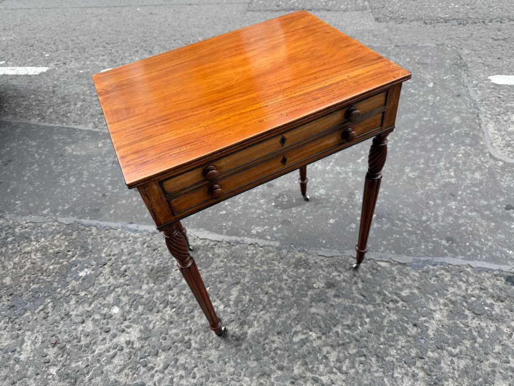 A Scottish Regency satinwood ladies work table featuring a rectangular top, two drawers with round knobs, spiral turned legs, and brass castors. View III