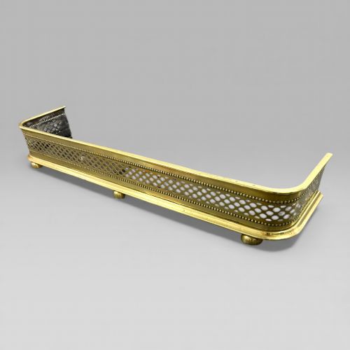 fig 1. A long Victorian brass fire fender featuring a pierced lattice pattern, beaded edge trim, and low support feet.