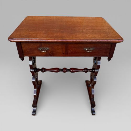 fig 1. A Victorian mahogany centre table featuring a rectangular top with moulded edge, two frieze drawers with brass drop handles, carved shaped end supports, and a turned stretcher.