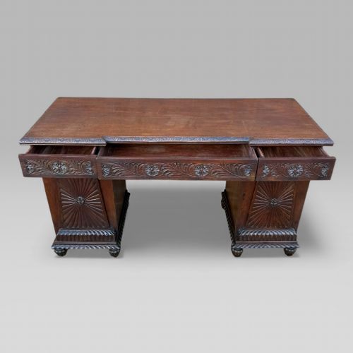 fig 2. A dark carved padouk wood sideboard featuring intricate floral frieze carvings, sunburst panel pedestals, and a central kneehole design.