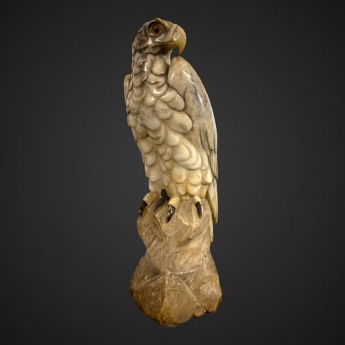 fig 1. A 19th-century carved veined white marble eagle statue with amber glass eyes perched atop a rock formation.