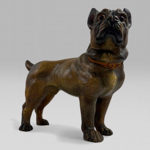 fig 1. A dark brown painted terracotta dog sculpture standing upright with glass eyes and a moulded collar.