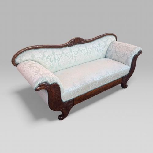 fig 2. A nineteenth-century French Empire flame mahogany sofa featuring carved scroll arms, a serpentine crest, and light blue damask fabric upholstery.