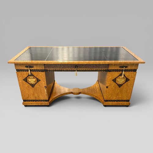 fig 1. A three-piece French Neoclassical office set featuring a satinwood pedestal desk with black trim, a matching glazed cabinet, and an armchair with a green leather seat.
