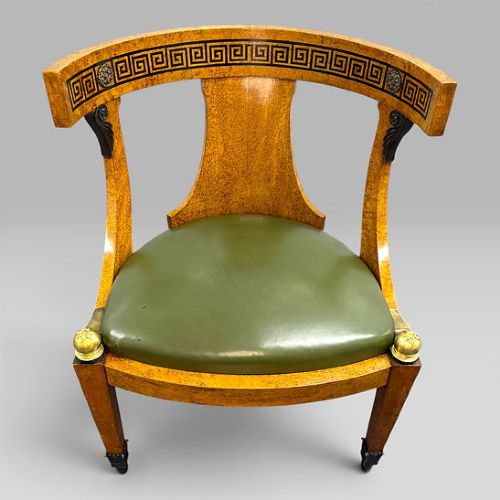 fig 6. A three-piece French Neoclassical office set featuring a satinwood pedestal desk with black trim, a matching glazed cabinet, and an armchair with a green leather seat.