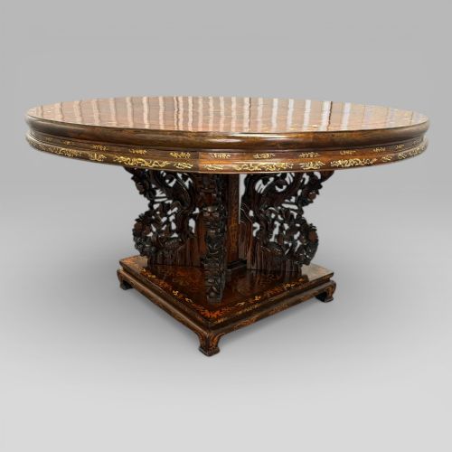 fig 3. A circular dark rosewood centre table featuring detailed marquetry inlays depicting ships, pagodas, and flora.