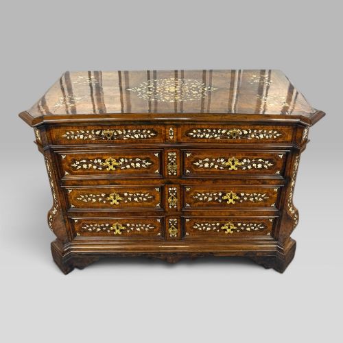 fig 1. An Italian Baroque walnut commode featuring floral bone inlays across six drawer fronts, side panels, and top surface, supported by bracket feet.