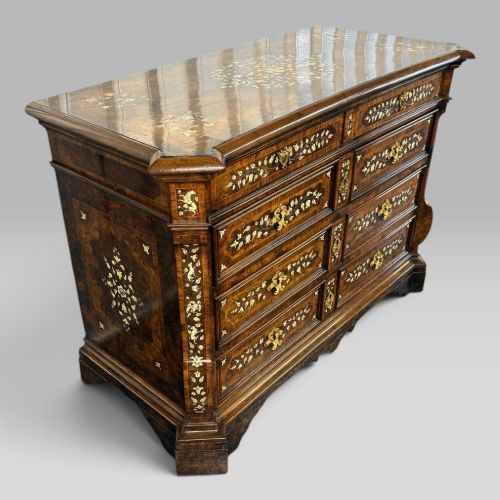 fig 2. An Italian Baroque walnut commode featuring floral bone inlays across six drawer fronts, side panels, and top surface, supported by bracket feet.