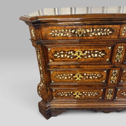 fig 3. An Italian Baroque walnut commode featuring floral bone inlays across six drawer fronts, side panels, and top surface, supported by bracket feet.