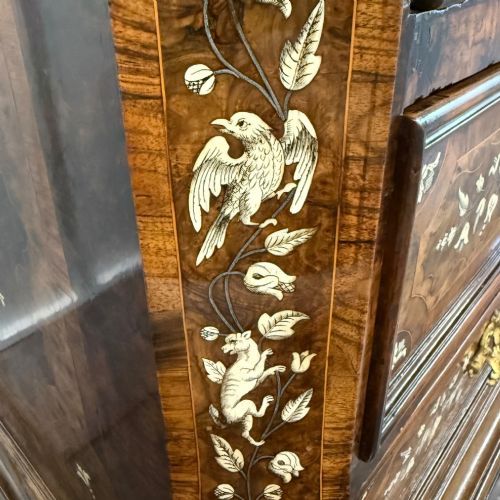 fig 8. An Italian Baroque walnut commode featuring floral bone inlays across six drawer fronts, side panels, and top surface, supported by bracket feet.