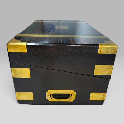 fig 3. A rectangular dark coromandel wood writing slope box bound with brass corner plates and straps.