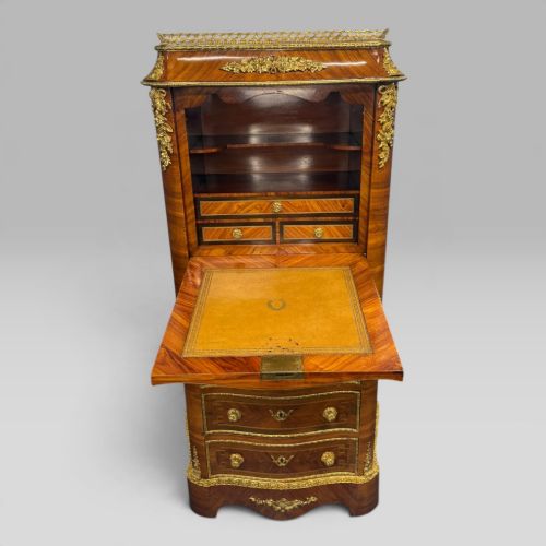 fig 2. A tall antique French kingwood and rosewood secretaire chest featuring parquetry veneers, ornate gilt bronze mounts, seven drawer fronts, and a pierced brass gallery top.