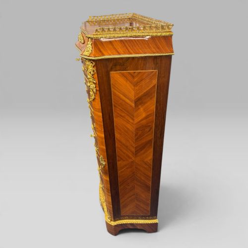 fig 4. A tall antique French kingwood and rosewood secretaire chest featuring parquetry veneers, ornate gilt bronze mounts, seven drawer fronts, and a pierced brass gallery top.