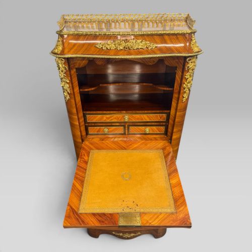 fig 6. A tall antique French kingwood and rosewood secretaire chest featuring parquetry veneers, ornate gilt bronze mounts, seven drawer fronts, and a pierced brass gallery top.