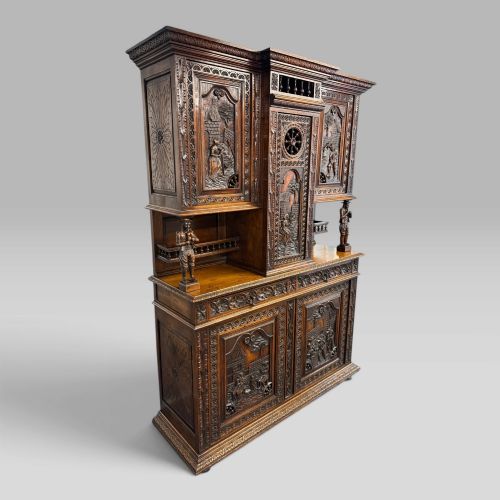 fig 2. A mid-nineteenth-century dark oak French Breton buffet cabinet with detailed folk carvings, relief panels, ship wheel motifs, and carved human figure supports.