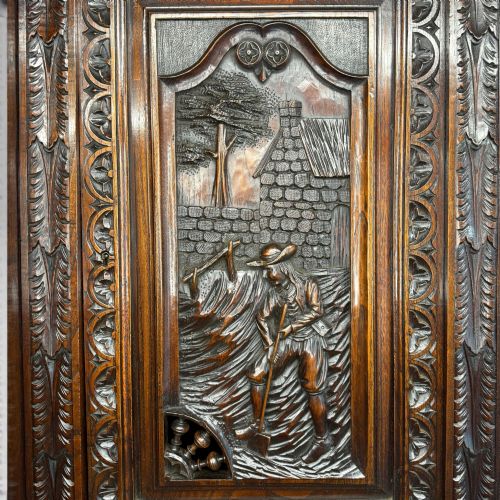 fig 6. A mid-nineteenth-century dark oak French Breton buffet cabinet with detailed folk carvings, relief panels, ship wheel motifs, and carved human figure supports.