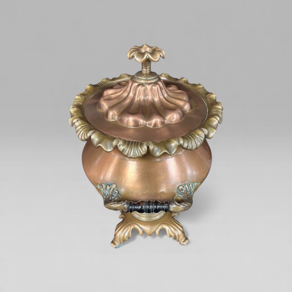 An antique Victorian copper samovar featuring a fluted lid, scalloped brass rim, cast brass side handles, a brass spigot, and a four-footed scroll base. View IV