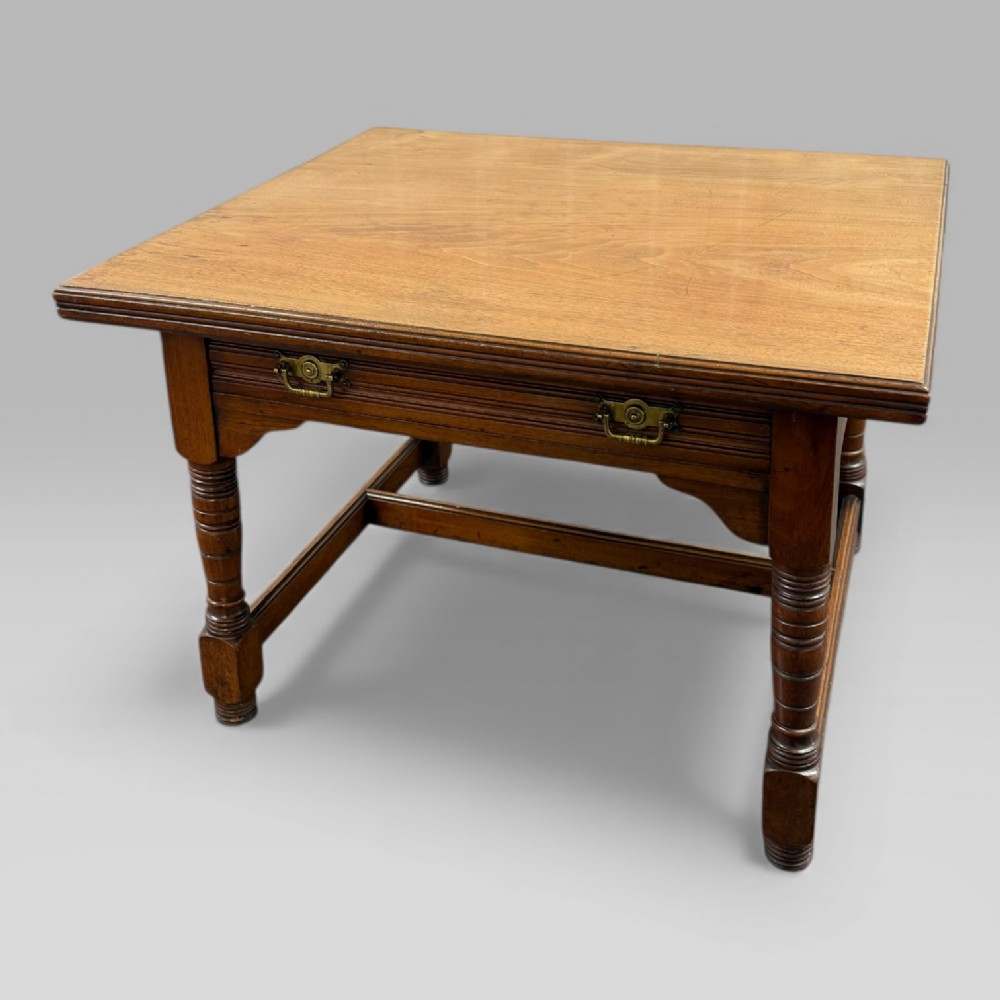 An antique walnut coffee table featuring turned legs, a rectangular top, brass drop handles, and an H-stretcher base. View II