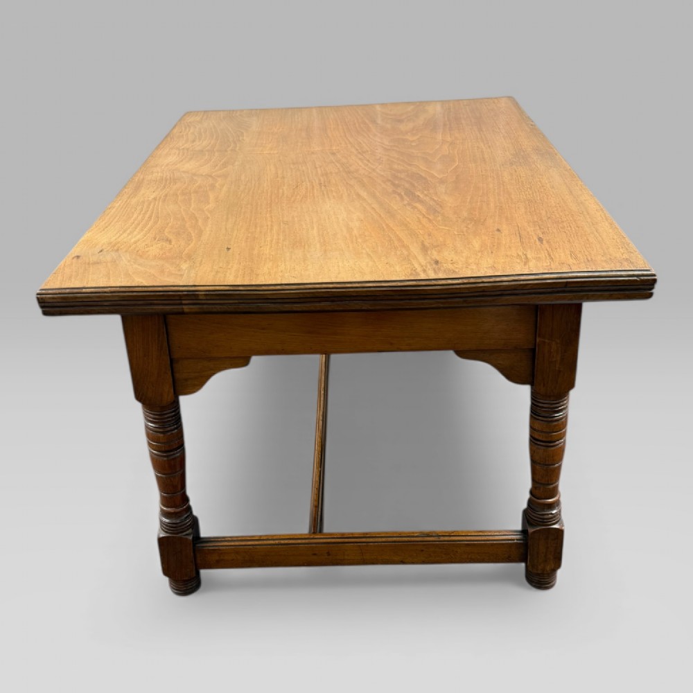 An antique walnut coffee table featuring turned legs, a rectangular top, brass drop handles, and an H-stretcher base. View VI