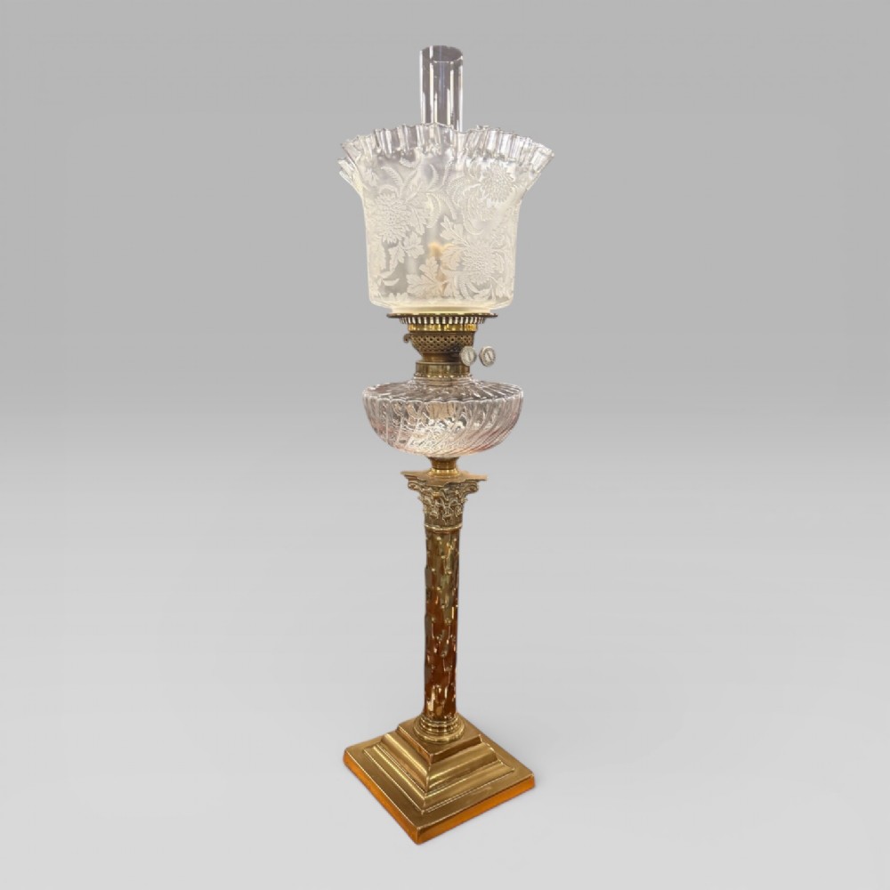 An antique Victorian oil lamp featuring a Corinthian style brass column base, clear glass reservoir, and an etched glass tulip shade with a frilled top rim. View III