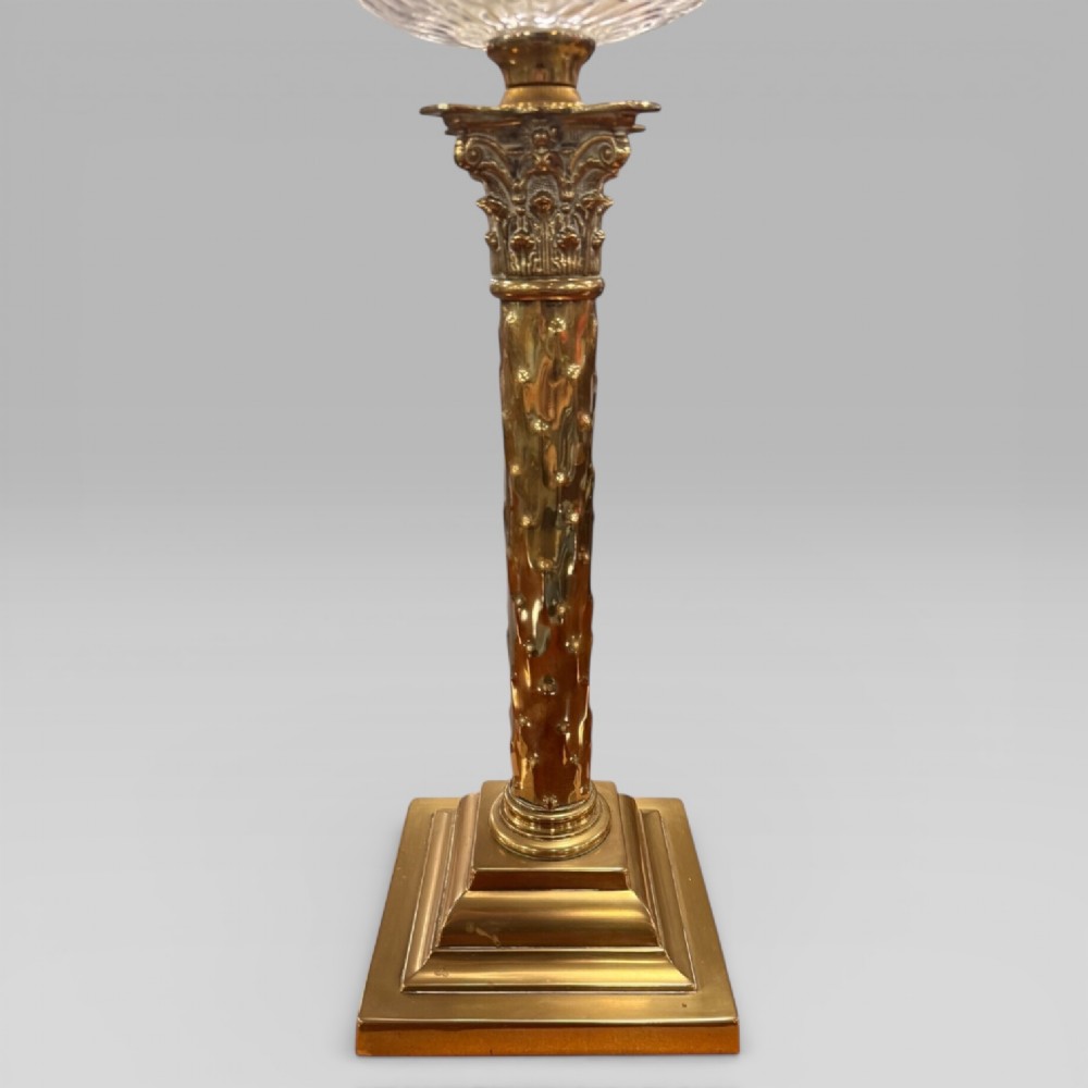An antique Victorian oil lamp featuring a Corinthian style brass column base, clear glass reservoir, and an etched glass tulip shade with a frilled top rim. View IV