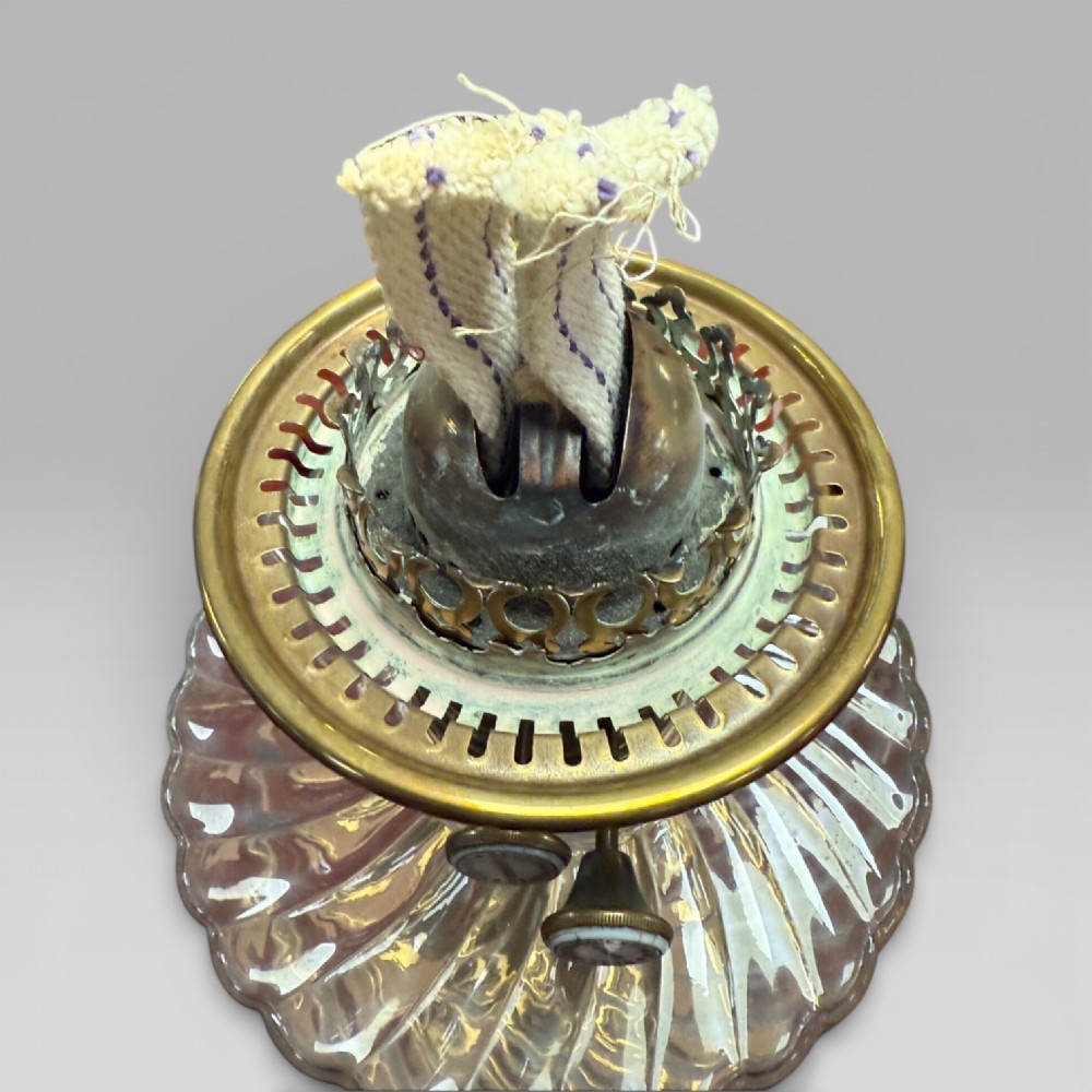 An antique Victorian oil lamp featuring a Corinthian style brass column base, clear glass reservoir, and an etched glass tulip shade with a frilled top rim. View IX