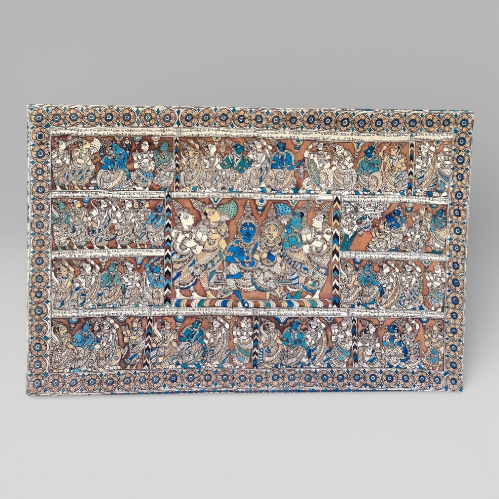 A rectangular Indian Kalamkari cotton textile displaying narrative panels filled with hand-drawn Hindu deities framed by a decorative floral border in blue, beige, and terracotta tones.