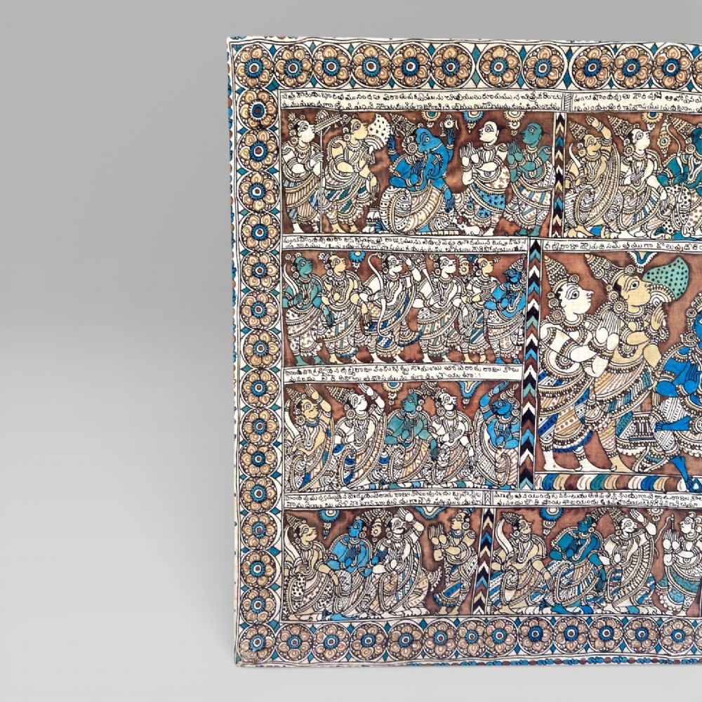 A rectangular Indian Kalamkari cotton textile displaying narrative panels filled with hand-drawn Hindu deities framed by a decorative floral border in blue, beige, and terracotta tones. View II