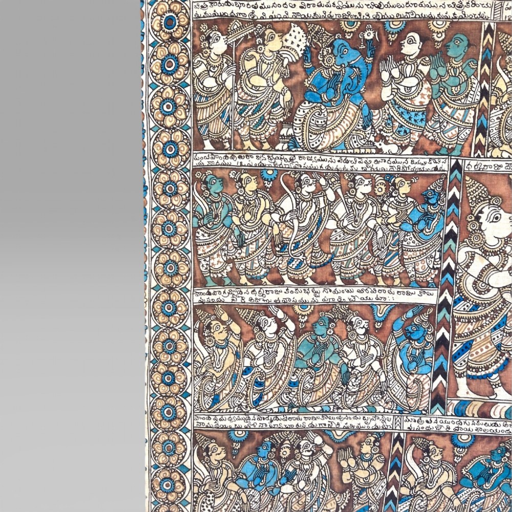 A rectangular Indian Kalamkari cotton textile displaying narrative panels filled with hand-drawn Hindu deities framed by a decorative floral border in blue, beige, and terracotta tones. View VII