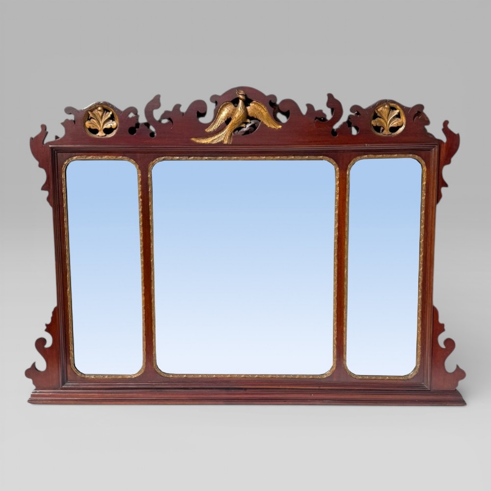 A 19th-century Chippendale style mahogany wall mirror featuring three glass panels, gilt trim, carved shell medallions, and a central gilded bird cresting.
