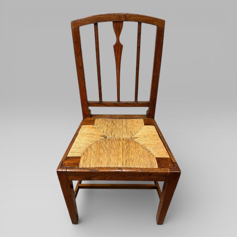 A 19th-century elm side chair featuring a woven rush seat, vertical back slats, and straight legs connected by stretchers. View II