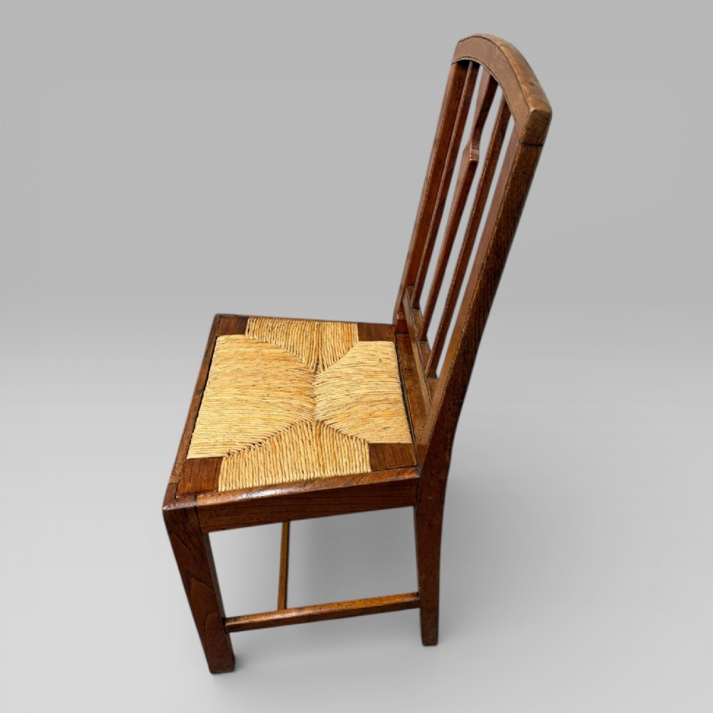 A 19th-century elm side chair featuring a woven rush seat, vertical back slats, and straight legs connected by stretchers. View IV