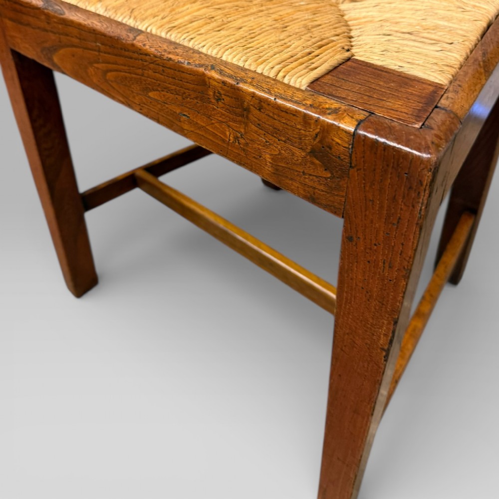 A 19th-century elm side chair featuring a woven rush seat, vertical back slats, and straight legs connected by stretchers. View VIII