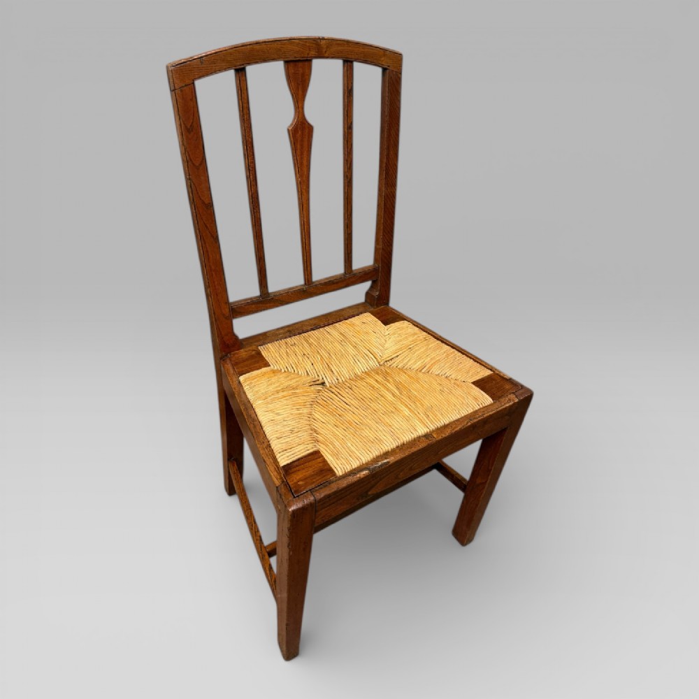 A 19th-century elm side chair featuring a woven rush seat, vertical back slats, and straight legs connected by stretchers. View XI