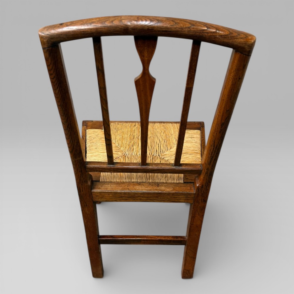 A 19th-century elm side chair featuring a woven rush seat, vertical back slats, and straight legs connected by stretchers. View XII
