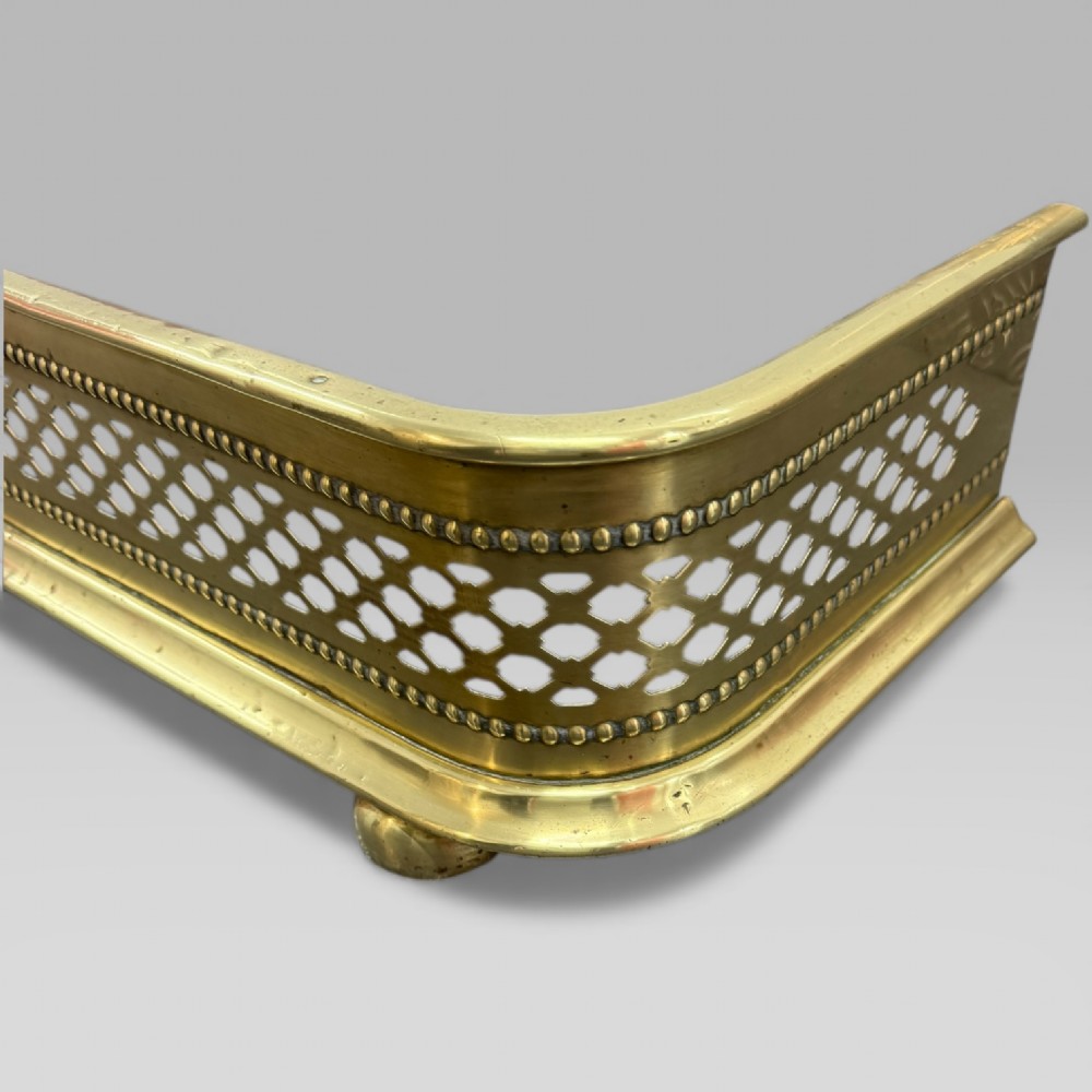 A long Victorian brass fire fender featuring a pierced lattice pattern, beaded edge trim, and low support feet. View III