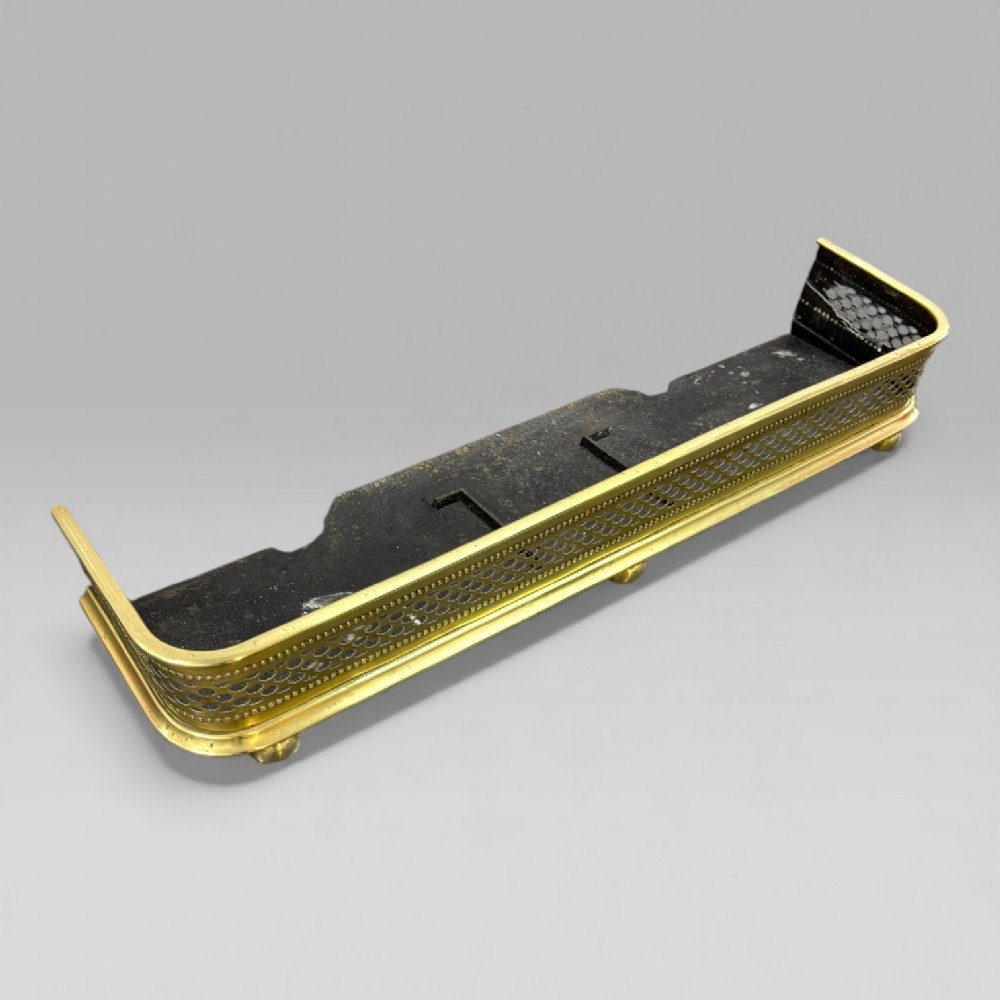 A long Victorian brass fire fender featuring a pierced lattice pattern, beaded edge trim, and low support feet. View VII